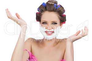 Cheerful woman with hands up and shaving foam on face