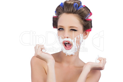 Cheeky model in hair curlers posing with shaving foam