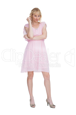 Stern blonde in pink dress posing