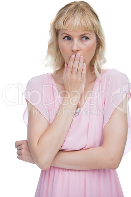 Blond woman putting her hand on her mouth