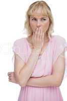 Blond woman putting her hand on her mouth