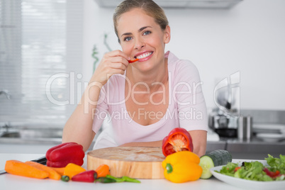 Cheerful woman eating vegetables