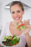 Smiling woman with salad dish