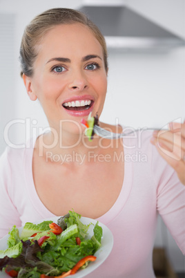 Pretty blonde eating salad