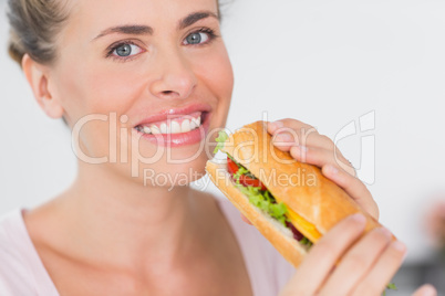 Cheerful woman holding sandwich