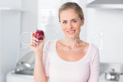 Cheerful woman holding apple in right hand
