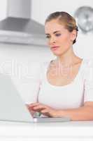 Concentrated woman typing on laptop