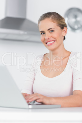 Cheerful woman typing on laptop