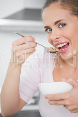 Pretty blonde woman eating bowl of cereal