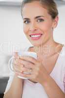 Radiant blonde woman drinking coffee