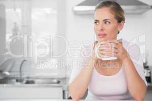Pensive woman having coffee