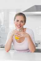 Cheerful blonde woman having orange juice