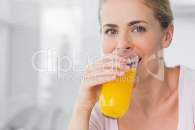 Cheerful woman drinking orange juice