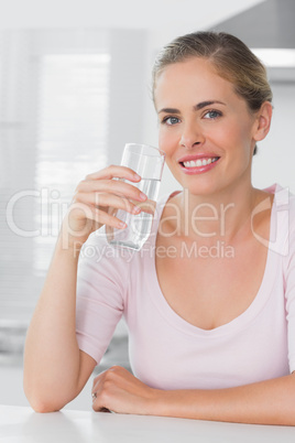 Cheerful woman holding glass of water