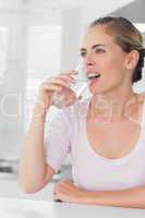 Pensive woman drinking water
