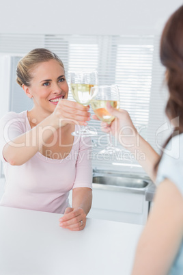 Radiant women having a toast with white wine