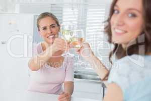 Happy women holding glasses of white wine