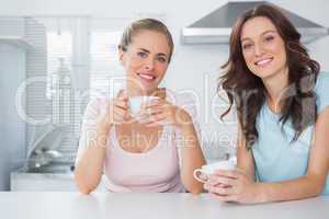 Cheerful friends having cup of coffee