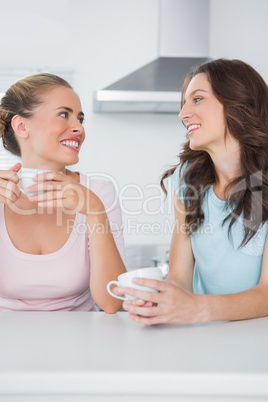 Happy friends having cups of coffee