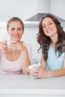 Cheerful friends having cups of coffee