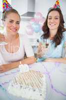 Cheerful women with white wine and birthday cake