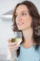 Thoughtful brunette drinking white wine
