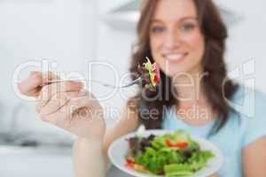 Brunette offering healthy salad