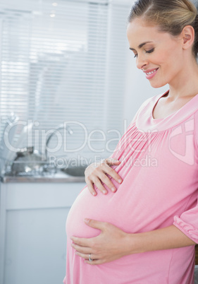 Expecting woman affectionately touching her belly