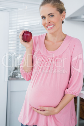 Expecting woman holding apple