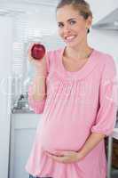 Expecting woman holding apple