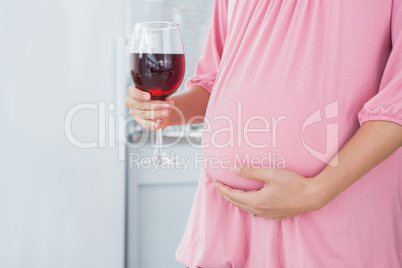Expecting woman with red wine in right hand