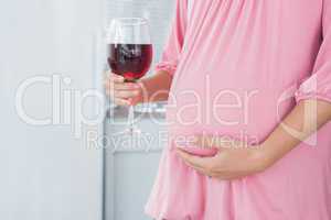 Expecting woman with red wine in right hand