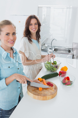 Women cooking together and looking at camera