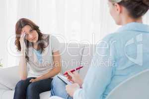 Worried woman sitting with therapist looking at her