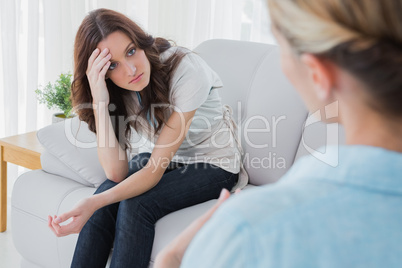 Worried woman sitting and looking at her therapist