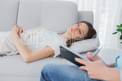 Thoughtful brunette lying on the couch