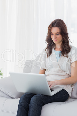 Concentrated woman with laptop on her knees