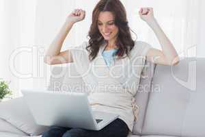 Overjoyed woman looking at her laptop
