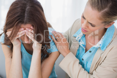 Upset woman being comforted by her understanding therapist