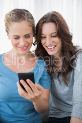 Smiling friends reading message on their phone
