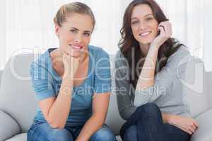 Women posing while sitting on the couch