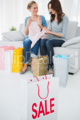 Friends with purchase and shopping bag on foreground