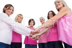 Women posing in circle holding hands looking at camera wearing p