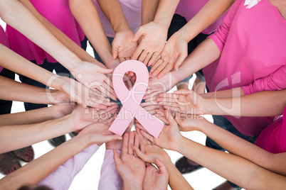 Hands joined in circle holding breast cancer struggle symbol
