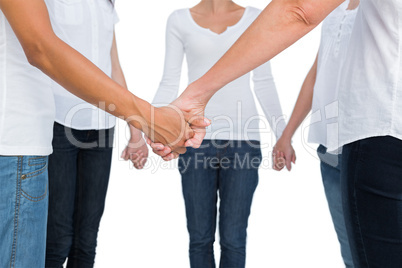 Women standing and holding hands in a circle