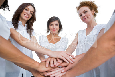 Cheerful models joining hands in a circle and looking at camera