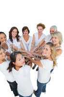 Happy female models joining hands in a circle and looking at cam