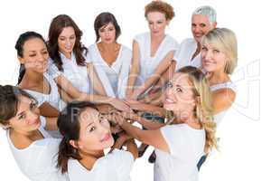 Female models joining hands in a circle and looking at camera