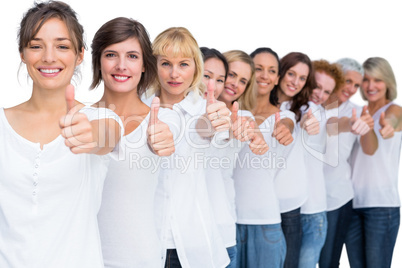 Cheerful casual models posing in a line thumbs up