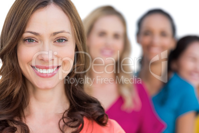 Smiling models in a line posing with focus on brunette